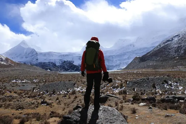 Una persona frente a un paisaje de montaña